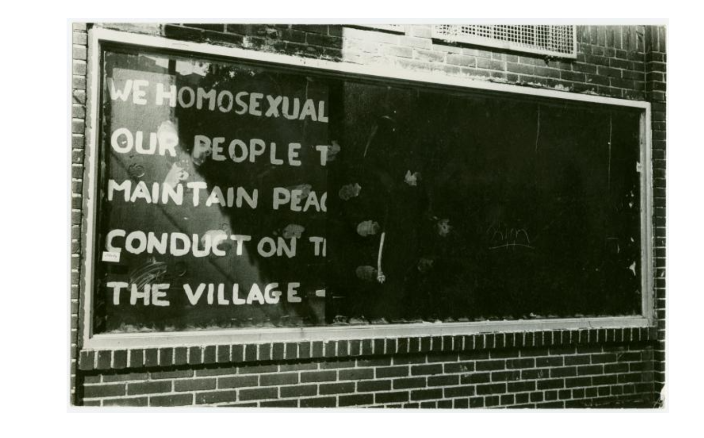 Black and white photo of smudged graffiti on the window of the Stonewall Inn. The visible text says 'We homosexual...our people t...maintain pea...conduct on t...the village -'